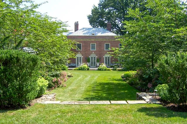 Manicured estate grounds and mixed garden borders leading to a brick Georgian manor
