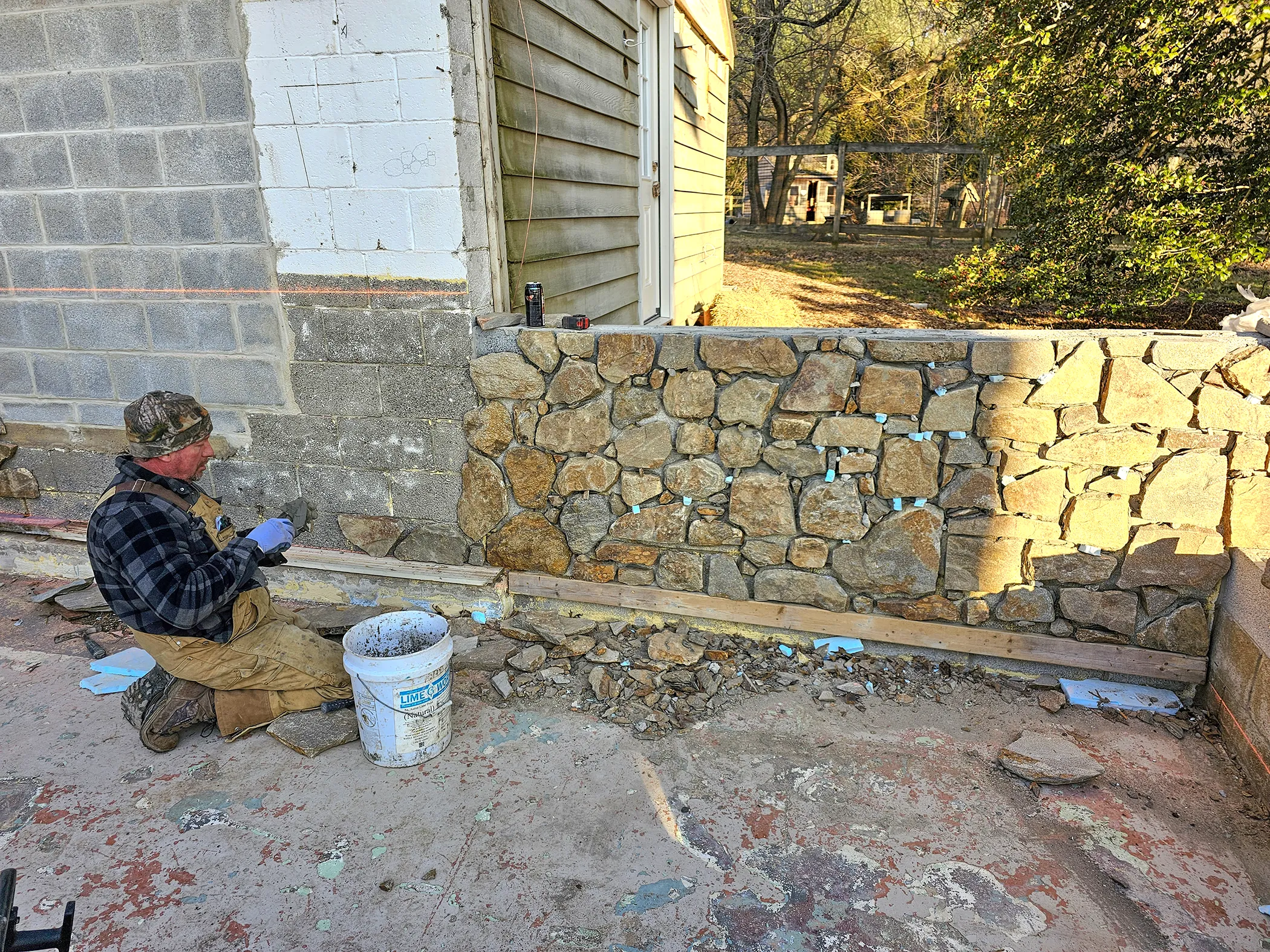 EHS mason hand-setting fieldstone veneer on courtyard wall at Fairville Friends School, Chadds Ford, PA
