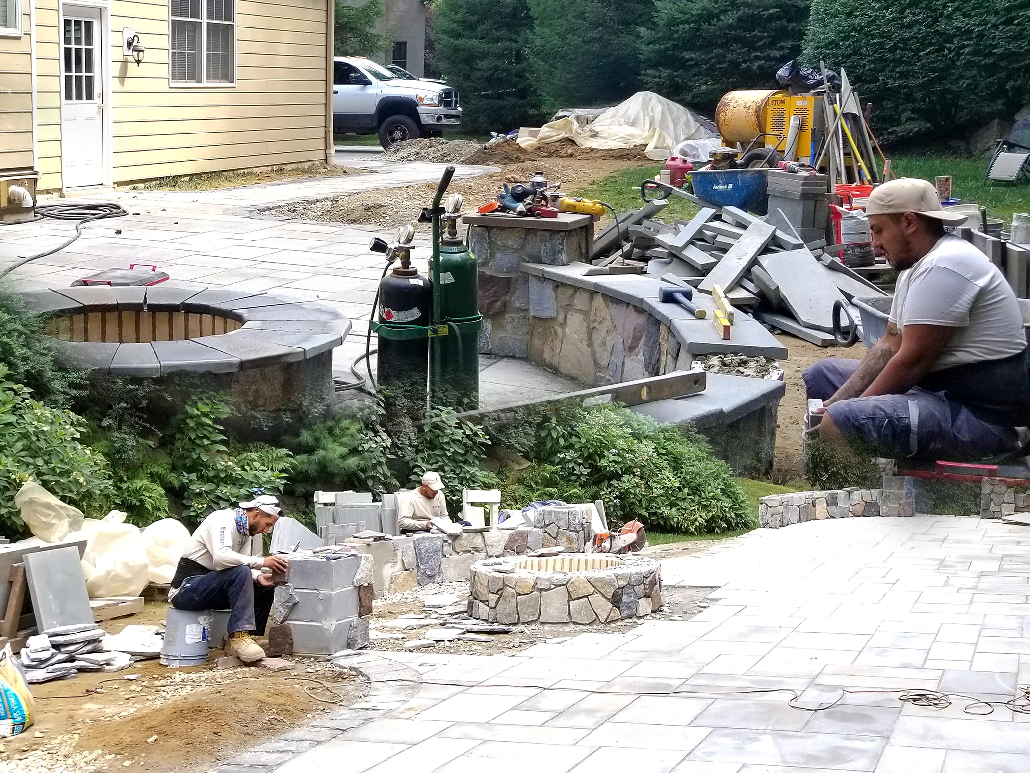 EHS masonry crew installing bluestone patio and fieldstone firepit terrace at Kennett Square residence, 2021