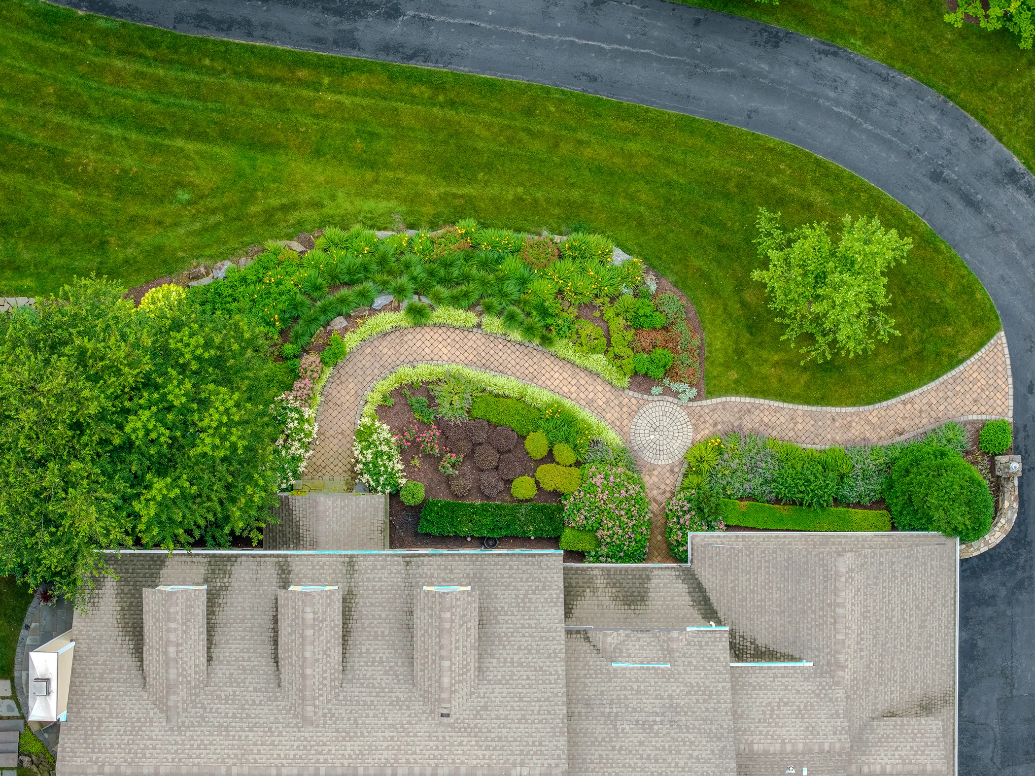 Overhead aerial of curved brick paver entry path and layered planting beds at Kennett Square residence, designed and installed by Eastern Horticultural Services