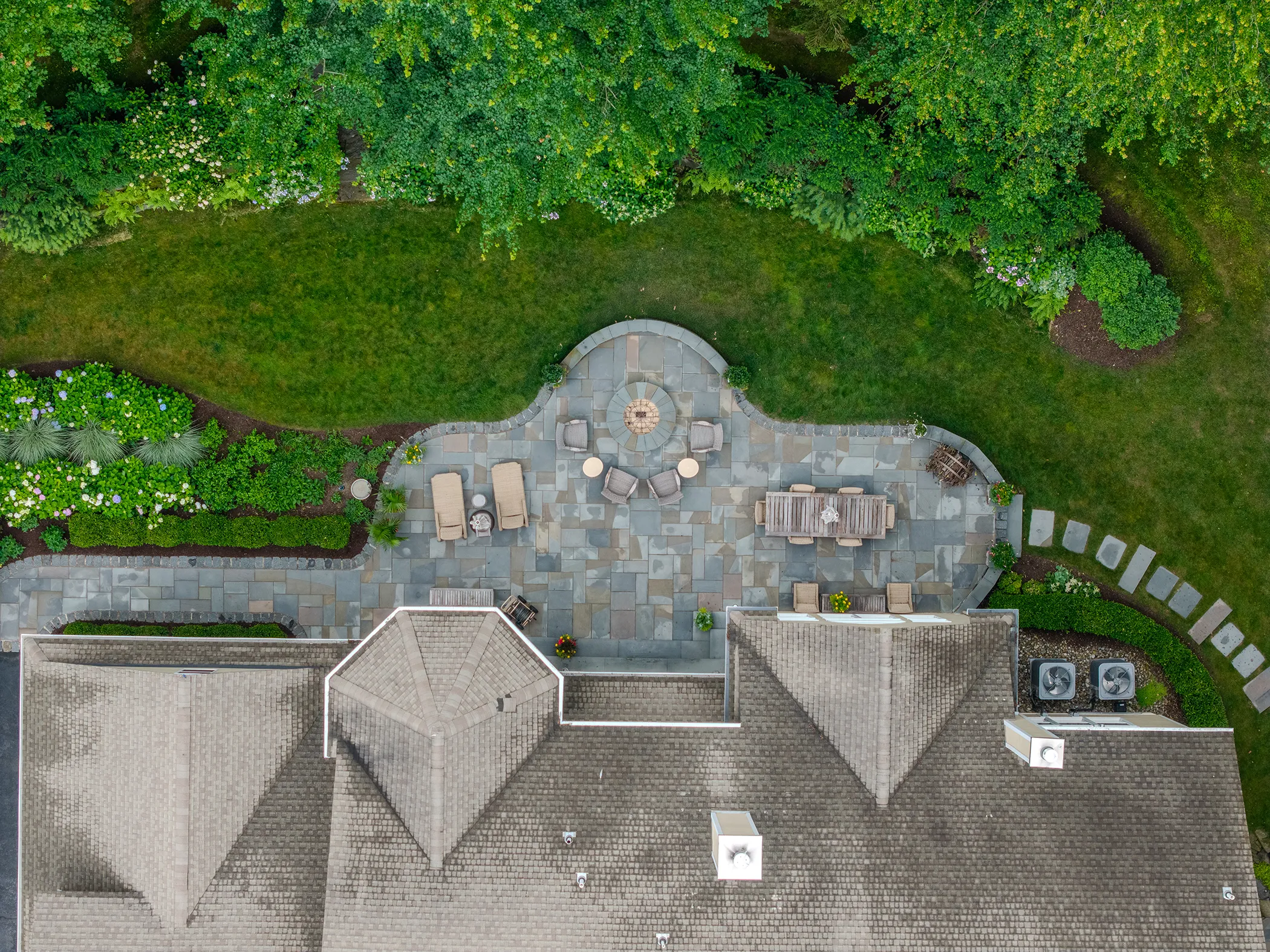 Overhead aerial of custom scalloped bluestone rear patio with fieldstone firepit terrace and curved seating wall, Kennett Square PA, Eastern Horticultural Services