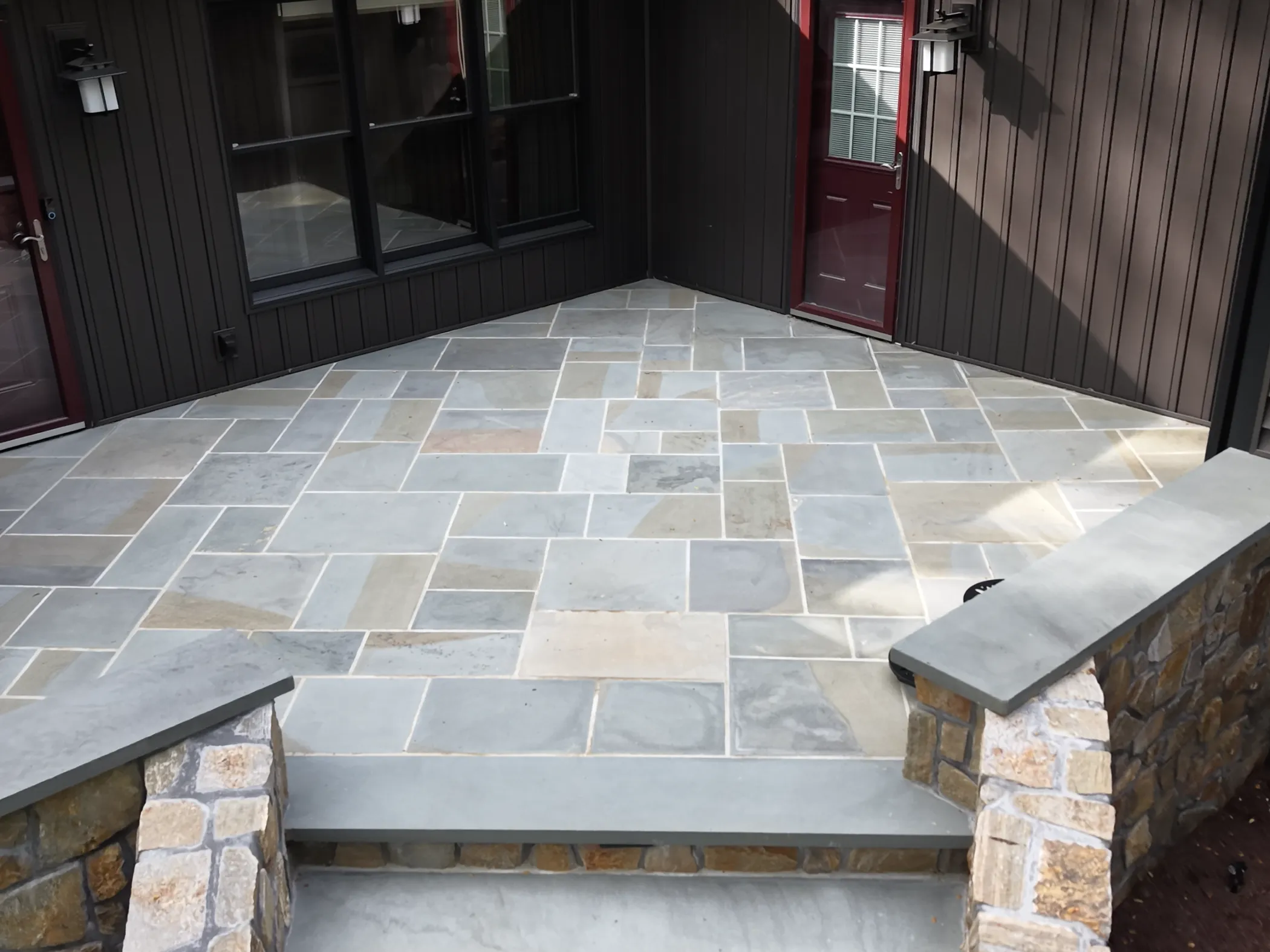 Cut bluestone herringbone terrace with fieldstone cheek walls and steps at North Star residence