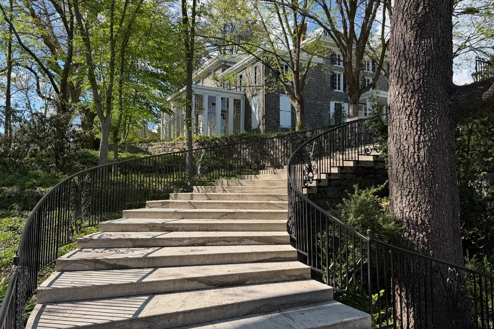 Curved marble entry stairs with ornate wrought iron railings leading to a historic estate garden — masonry by Eastern Horticultural Services, Gibraltar Estate, Wilmington DE