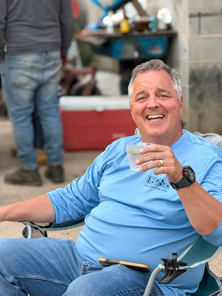 John Winterbottom laughing in a camp chair with a drink after tasting every contestant's pepper